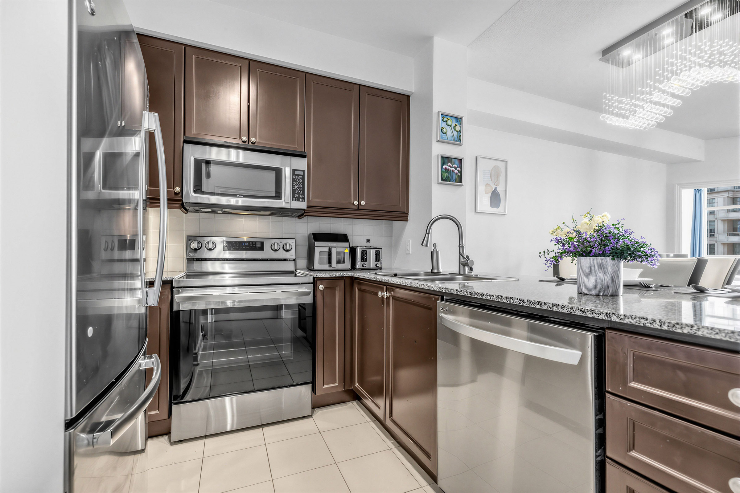 Condo kitchen with polished dark granite breakfast bar.