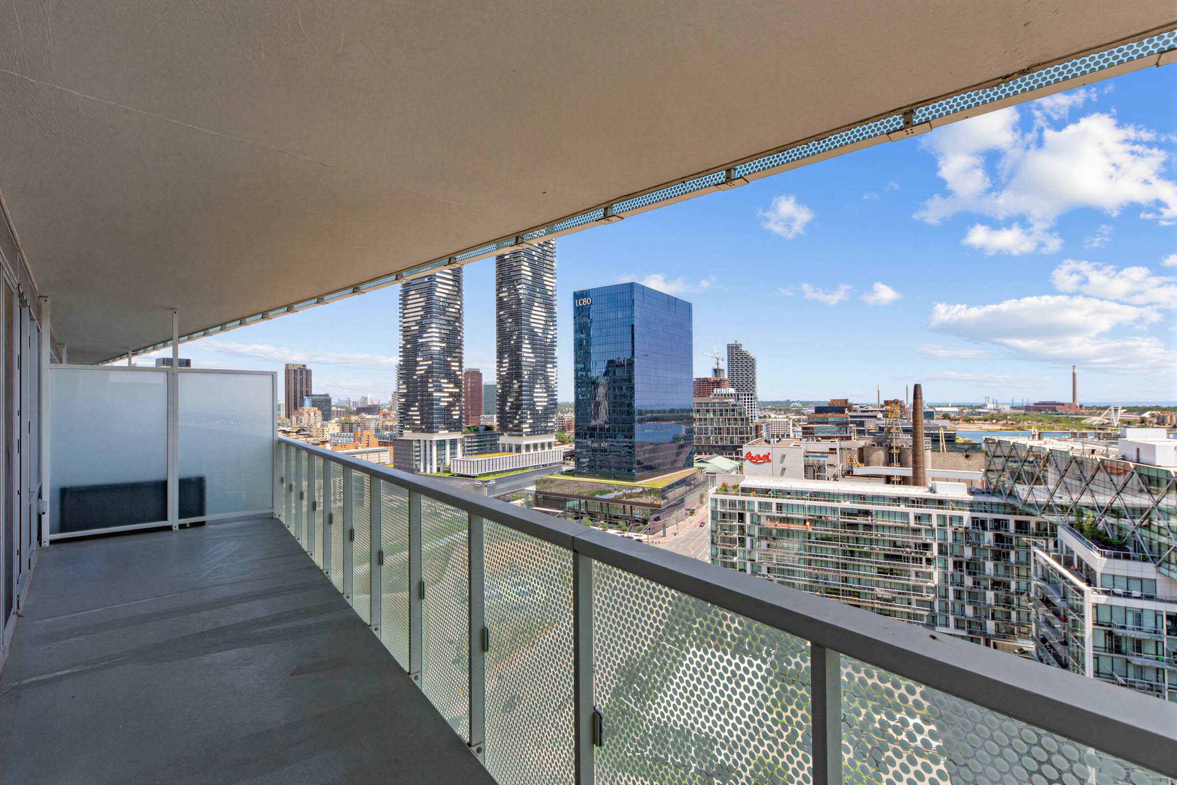 15 Queens Quay E Unit 1901 balcony with opaque privacy divider and view of Toronto waterfront.