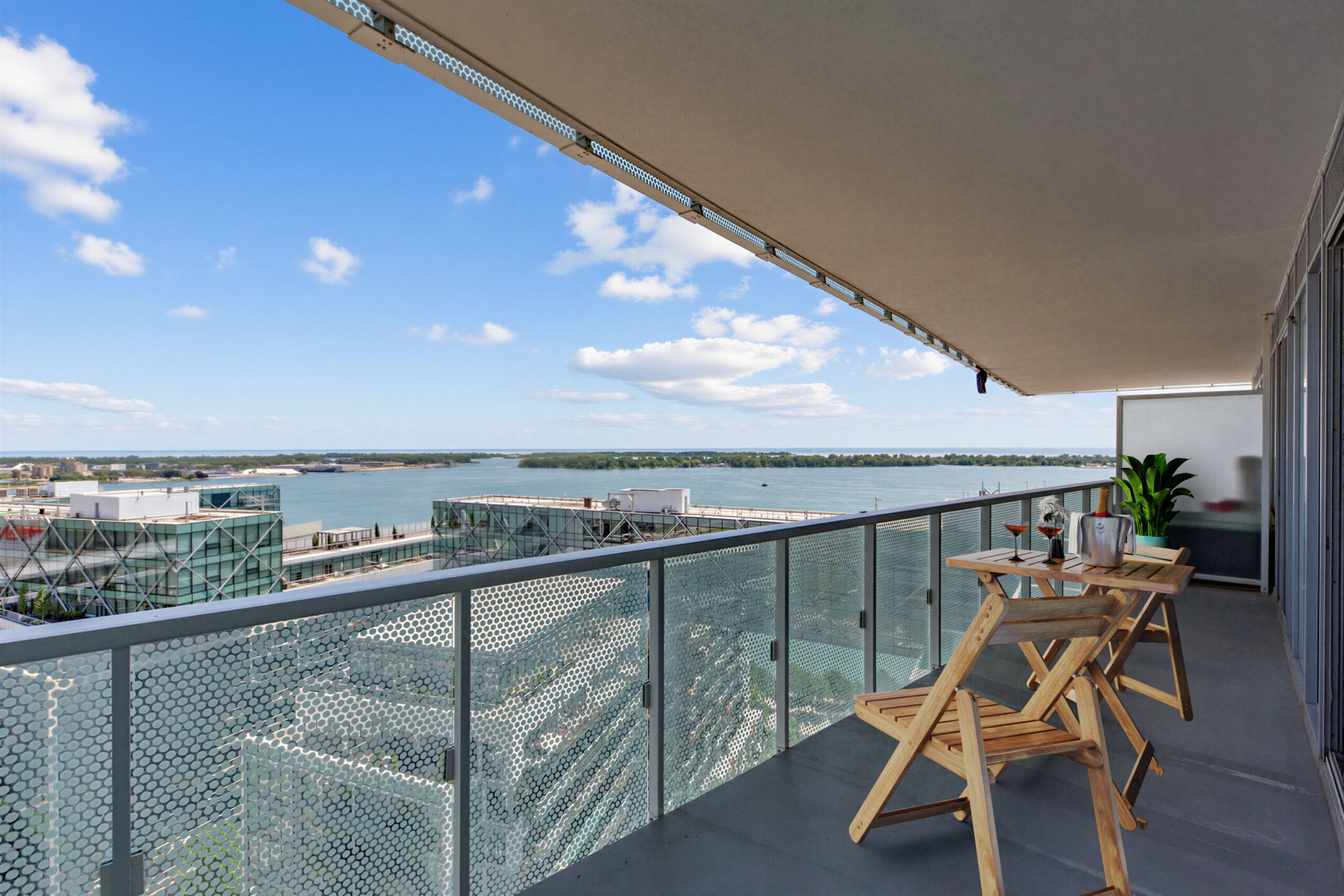 Balcony with patio furniture and view of Toronto islands and condos.