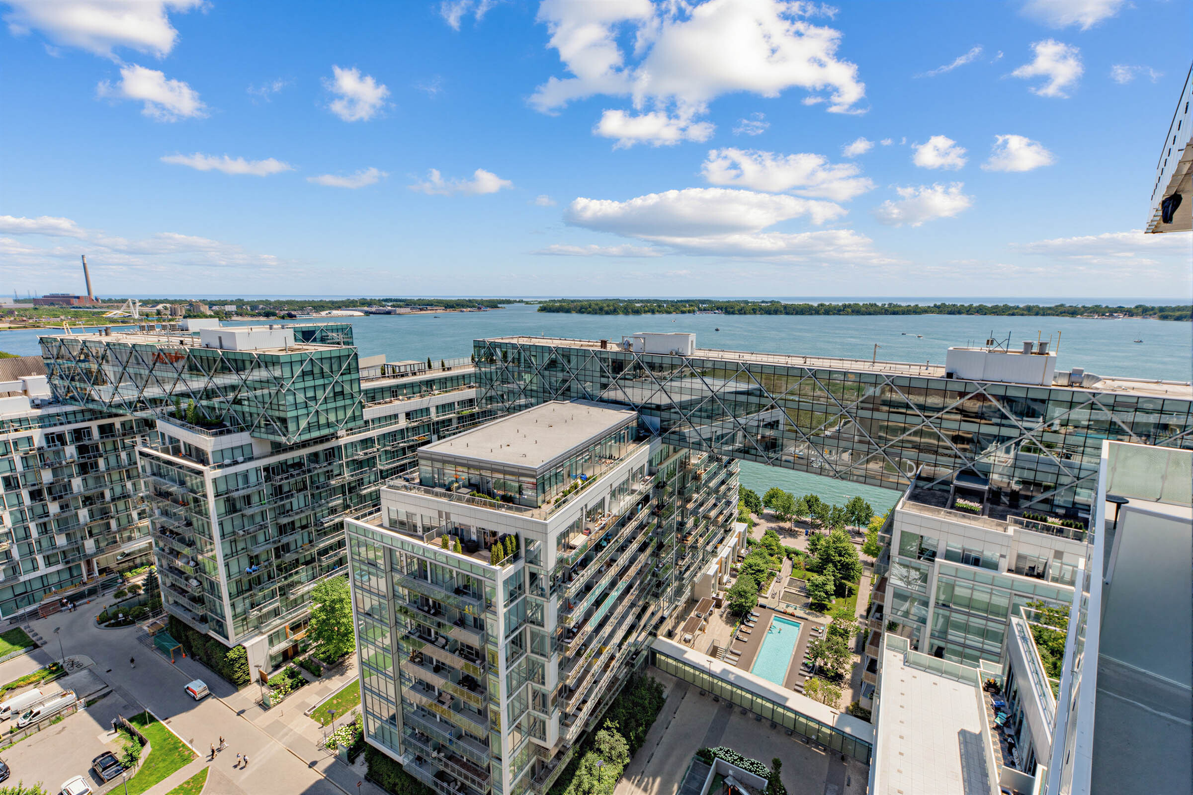 View from 15 Queens Quay E Unit 1901 balcony showing waterfront condos, Lake Ontario and Toronto Islands in distance.
