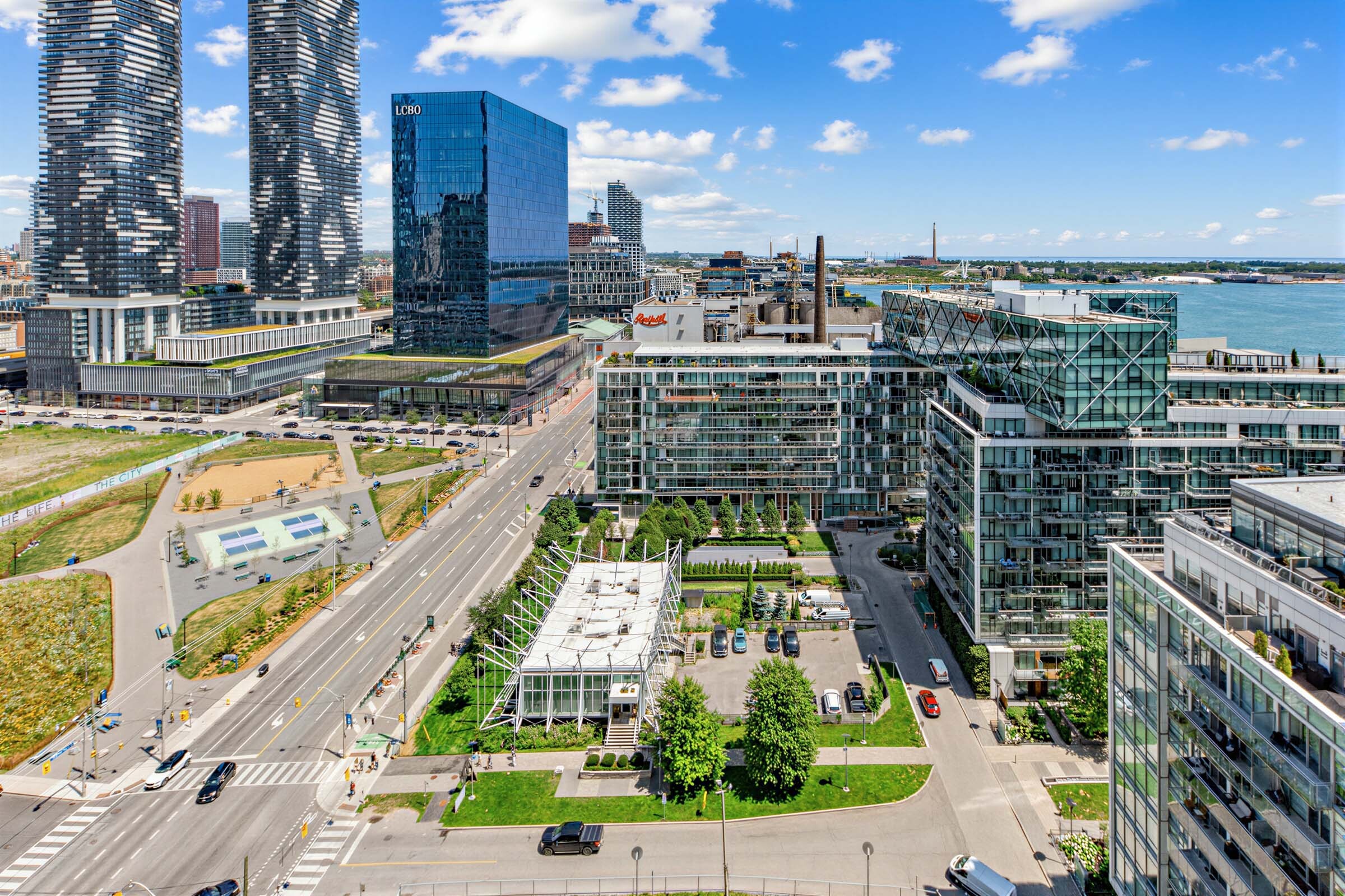 View of Toronto waterfront buildings and Lake Ontario from 15 Queens Quay E Unit 1901 balcony.