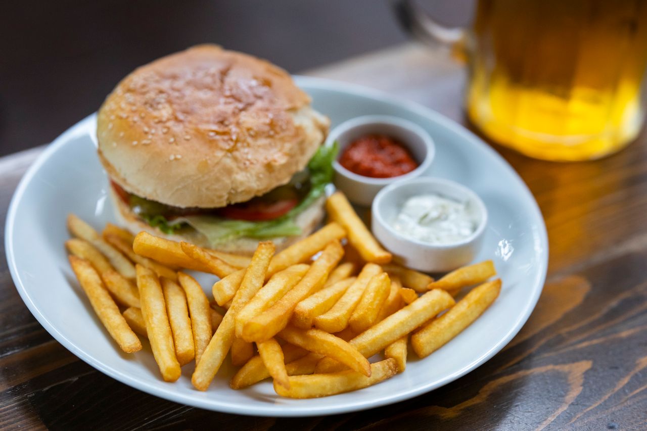 Food plate with burger fries and beer.