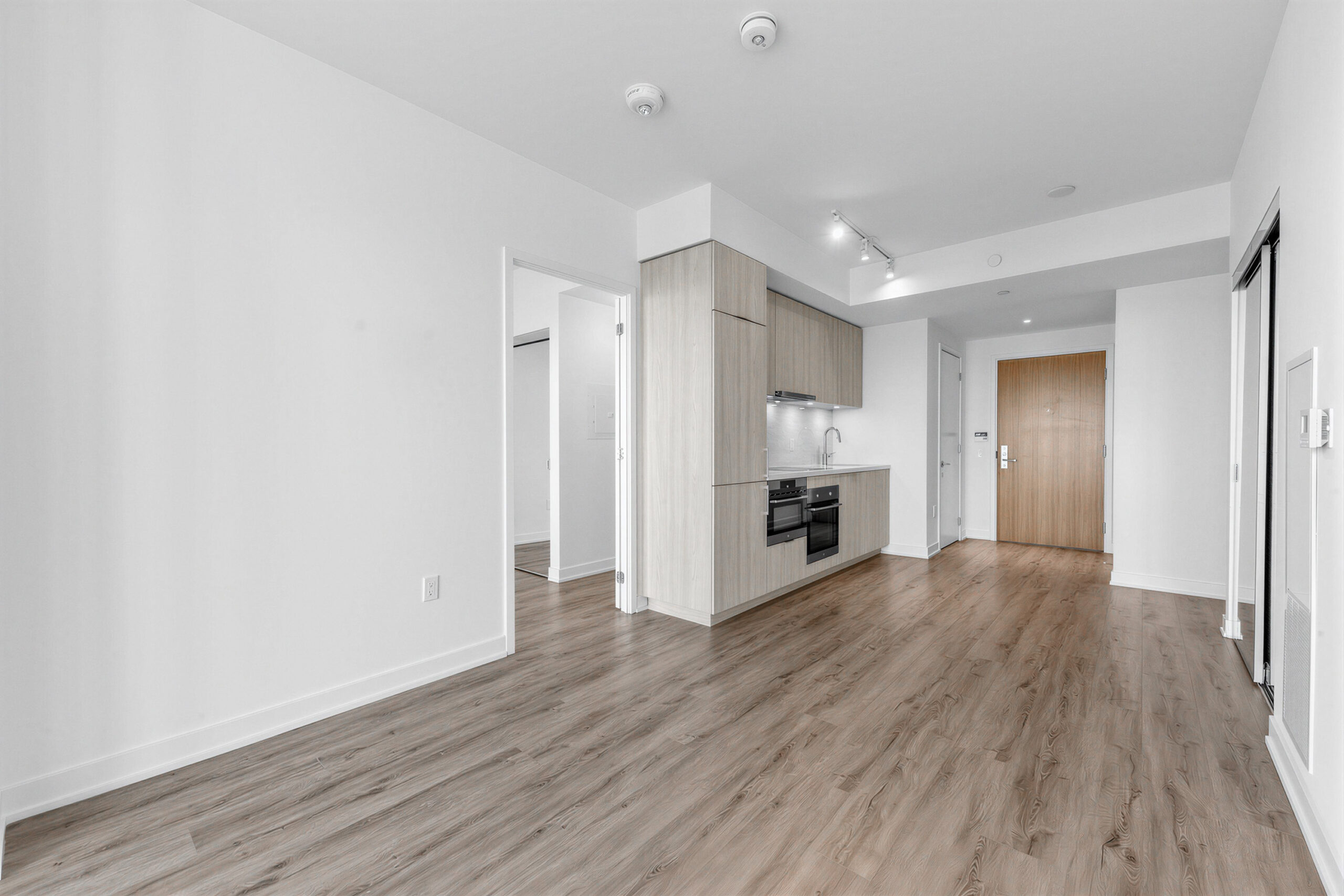 Condo living room, dining room and kitchen with new wide-plank hardwood floors.