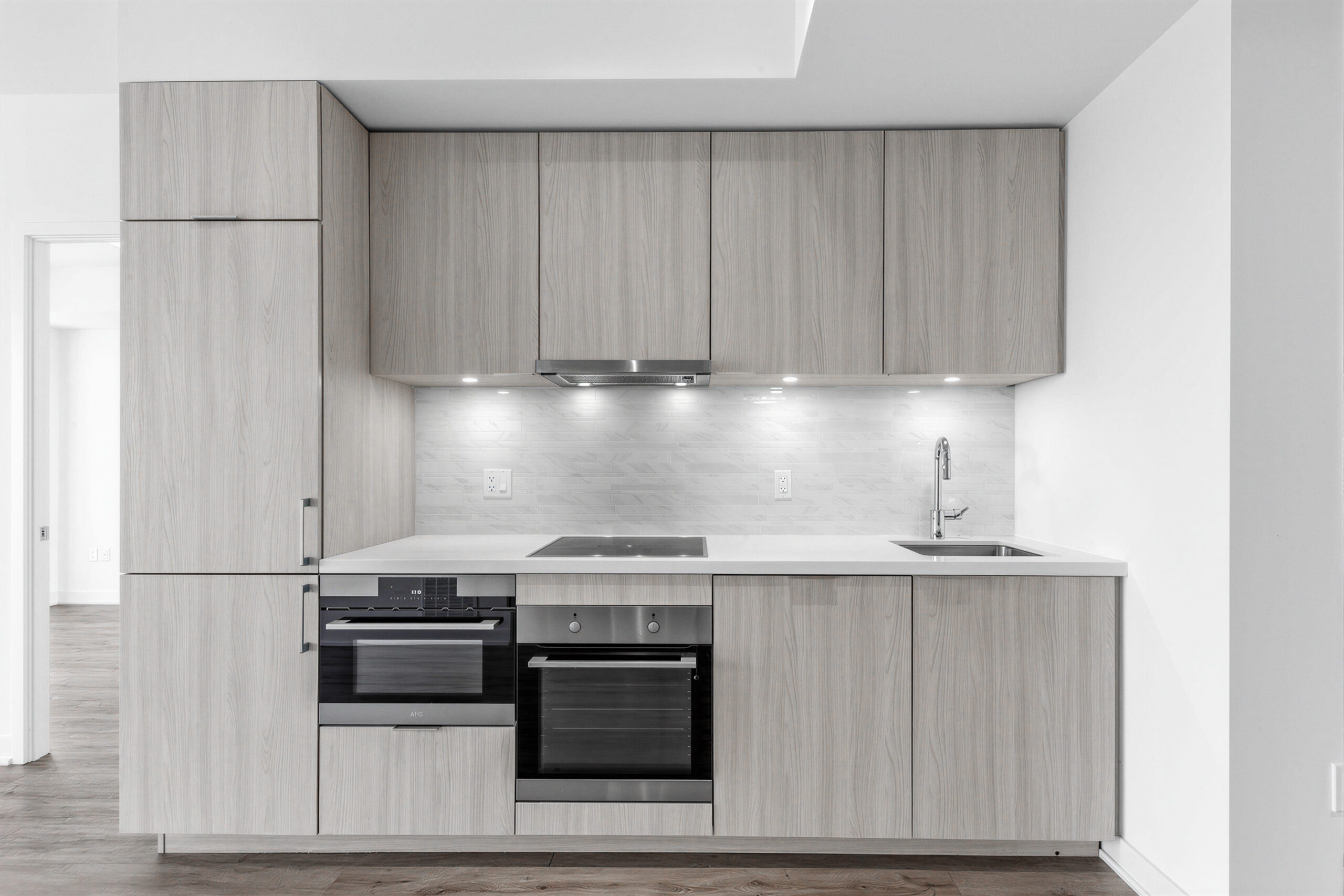 Linear condo kitchen with soft-close storage cabinets.