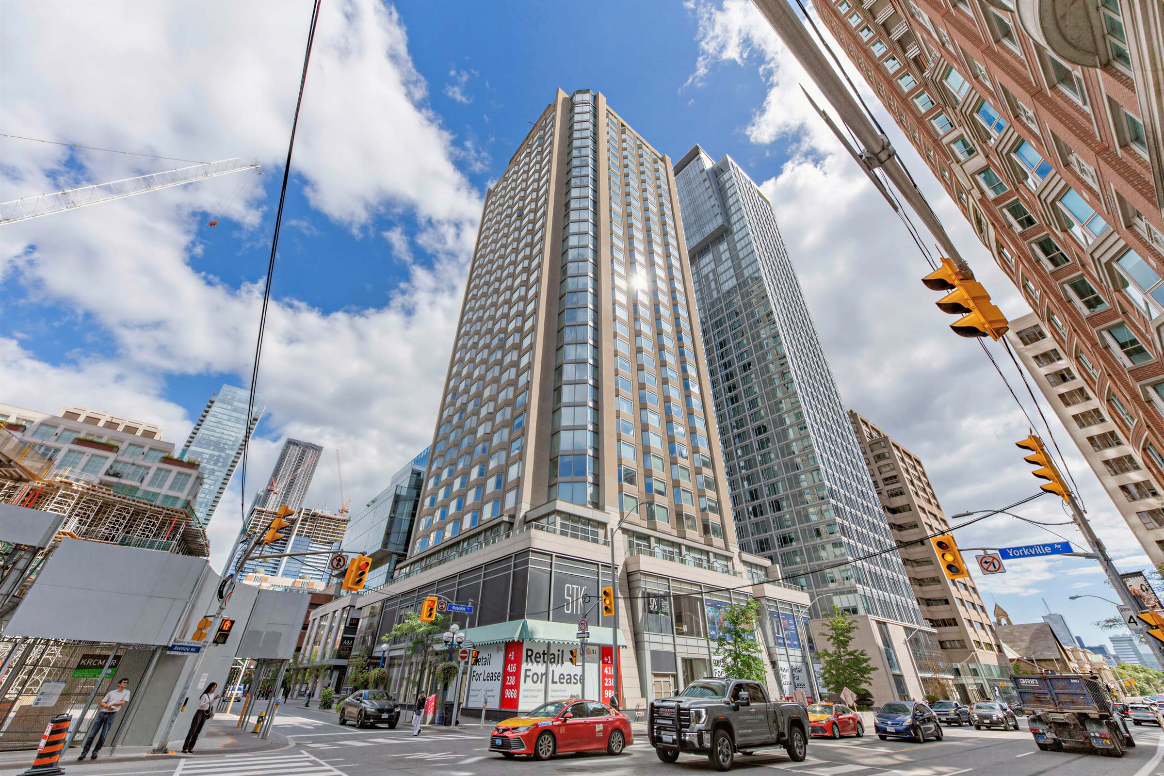 Across the street shot of Residences of Yorkville Plaza condo with STK signage on podium base.