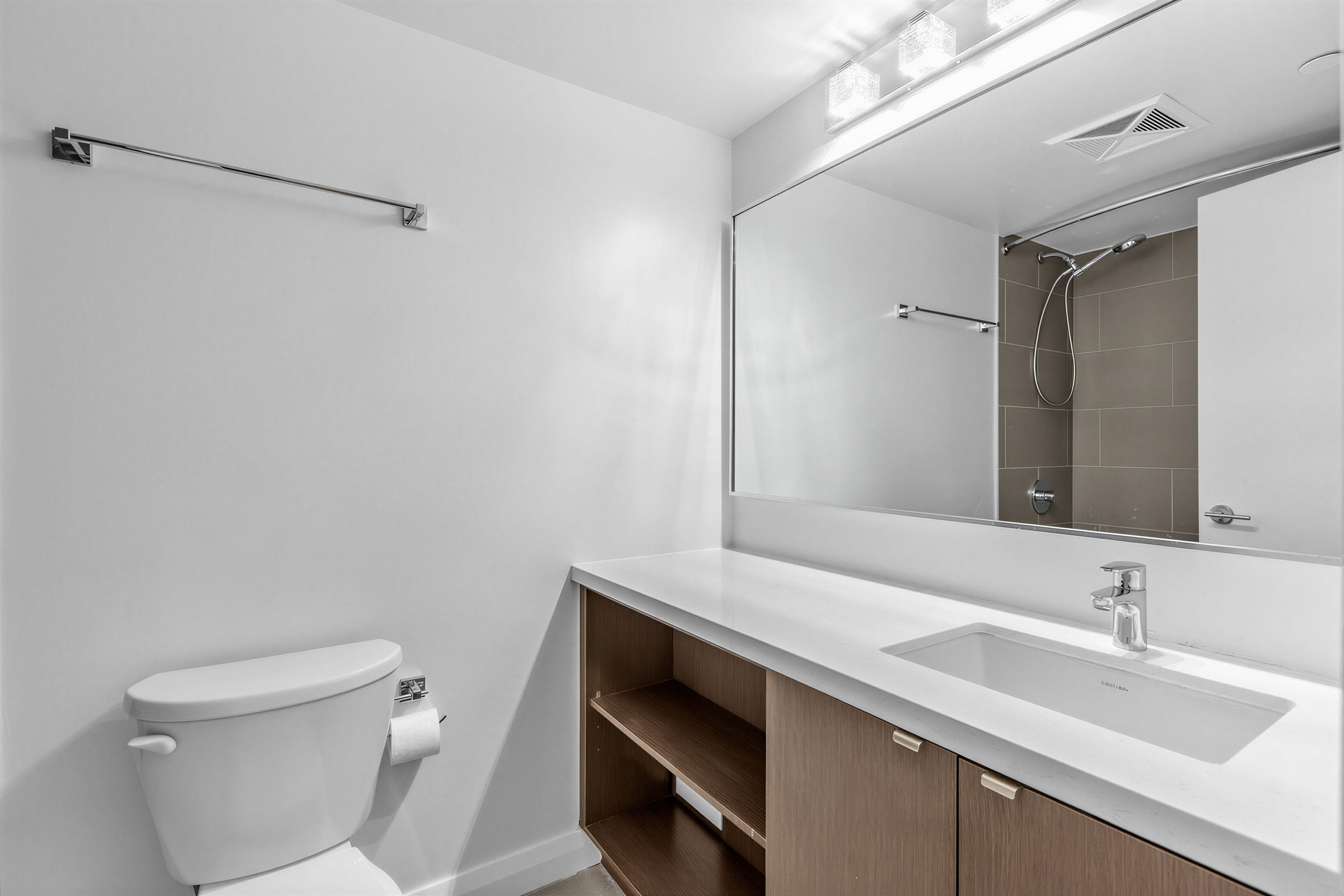 155 Yorkville Ave Unit 1607 bathroom with built-in vanity with cabinets, open shelves, large mirror and wall-mounted light fixture.