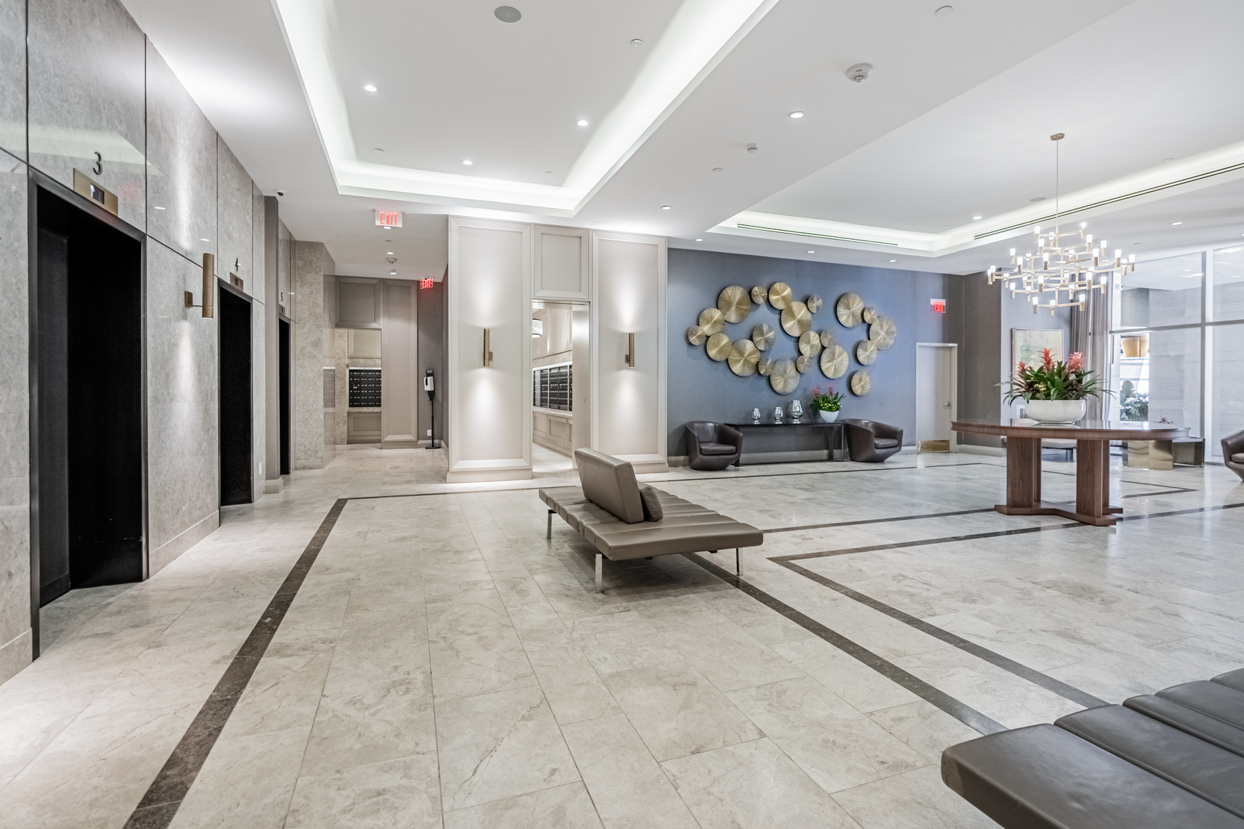 Yorkville Plaza's lobby with chandelier, metallic wall art and modern décor.