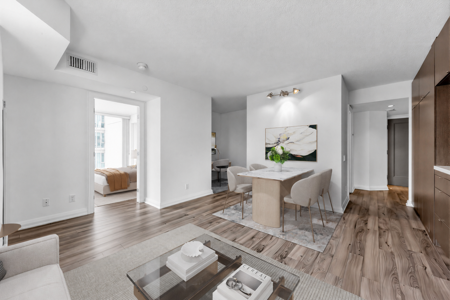 Staged condo dining and living rooms with dinette set and coffee table.