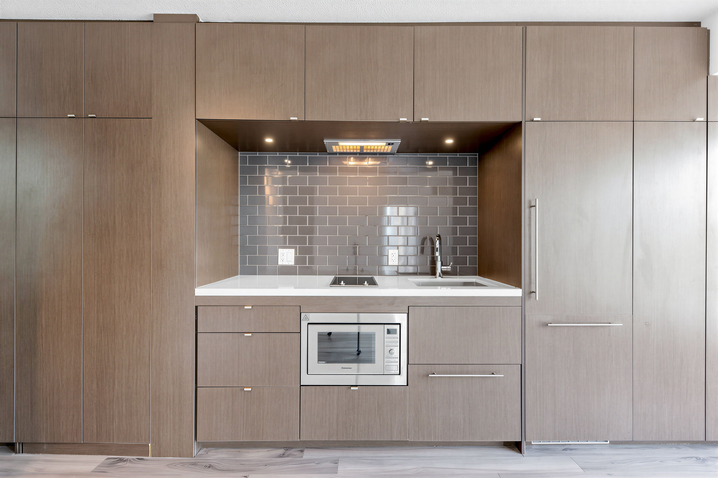 155 Yorkville Ave Unit 1607 linear recessed kitchen with tall, floor-to-ceiling cabinets.